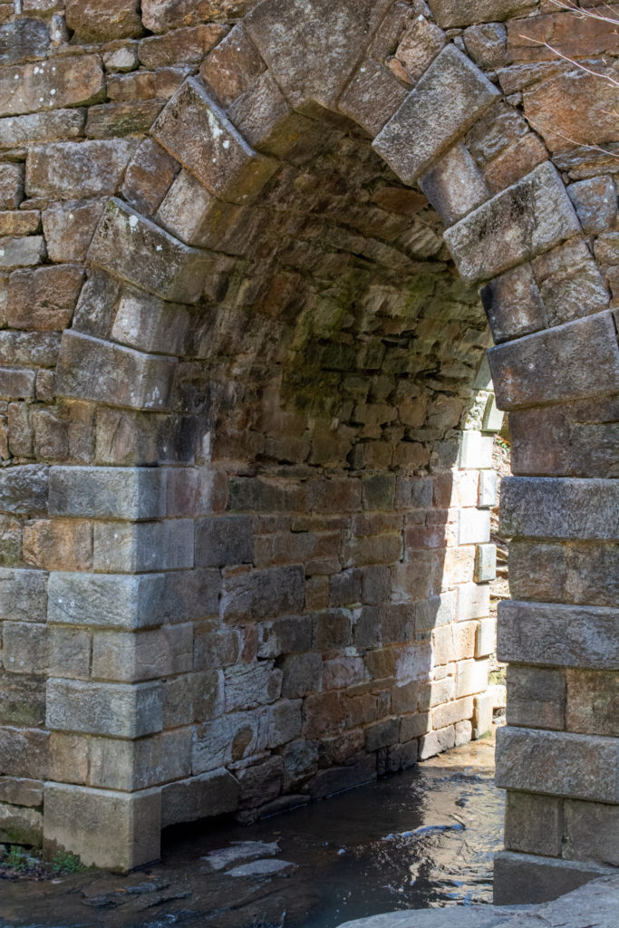 View of the base of an old stone bridge